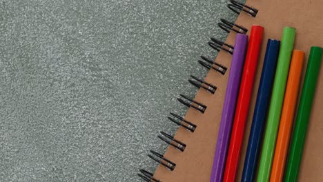 animación de lápices de colores y bloc de dibujo en la mesa