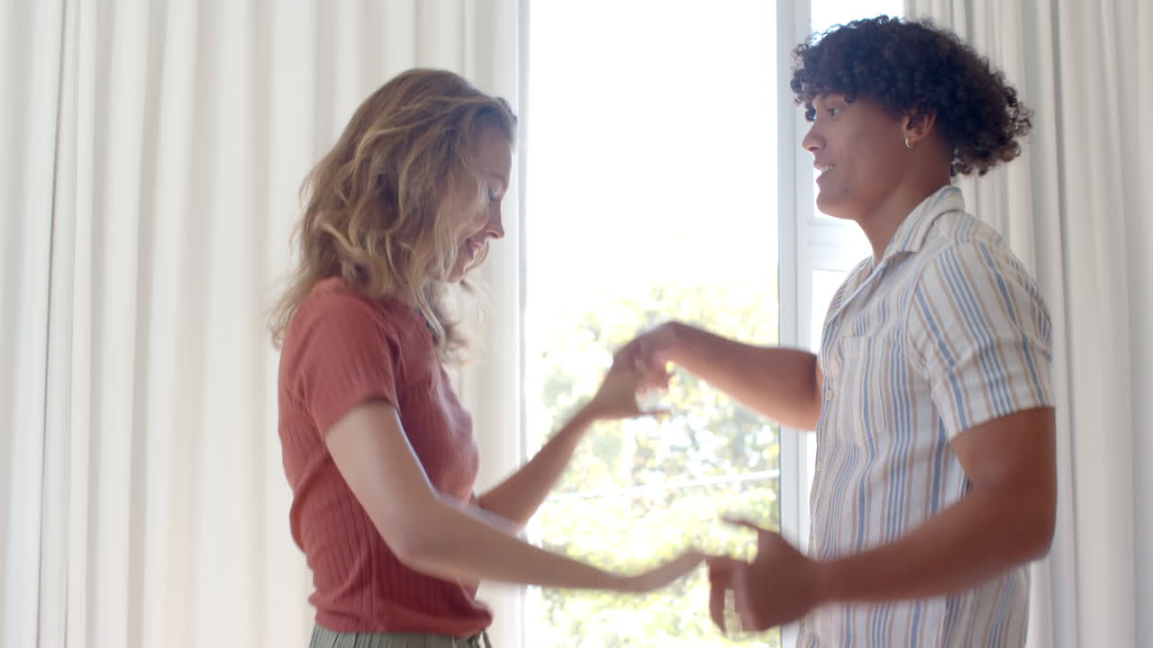 Dancing together at home, happy diverse couple sharing joyful moment