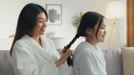 mother braiding daughter's hair