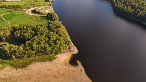 hermoso ascenso de drones que revela el río daugava y el jardín conmemorativo de liktenarz en koknese, letonia.