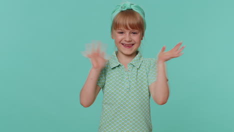 Happy-toddler-children-girl-smiling-friendly-at-camera-and-waving-hands-gesturing-hello-or-goodbye