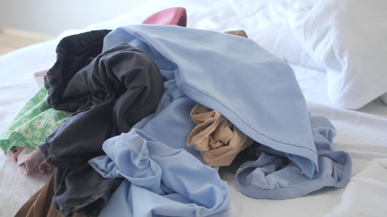 침대 위 에 있는 옷 어리