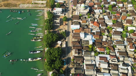 Vista-Aérea-De-Arriba-Hacia-Abajo-Del-Pueblo-De-Pescadores-En-El-Puerto-Pesquero-De-Awang,-Muchos-Barcos-En-La-Orilla-Del-Mar,-Casas-En-La-Azotea-En-La-Isla,-Lombok,-Mertak,-Indonesia