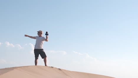 man recording himself with a smart phone at desert, creating content for his social media