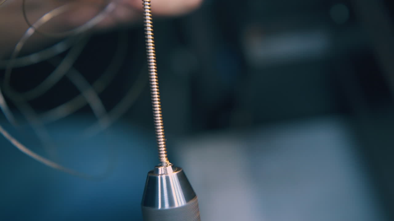 el joyero se quita la espiral de oro del primer plano de la herramienta de bobinado