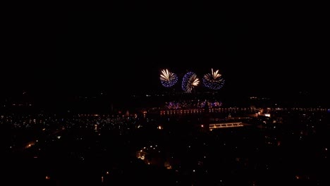 Fireworks-burst-over-Venice-at-night-during-the-festive-Carnival-season,-aerial-view