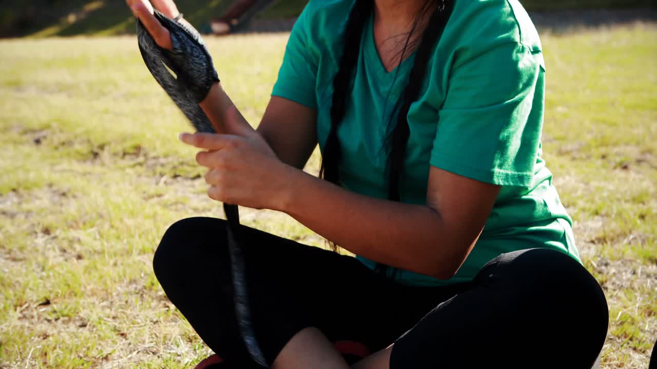 Teenage girl wearing boxing band in hand during obstacle course