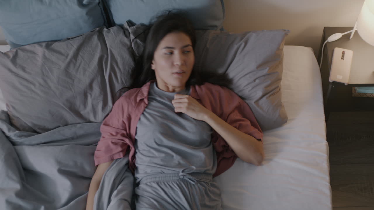 Woman Checking Phone In Bed