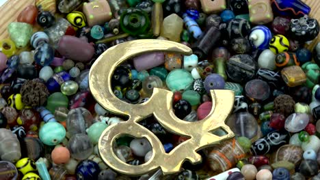 rotating brass om sign on indian beads background