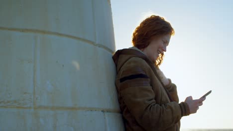 donna che usa il telefono cellulare al molo 4k