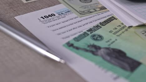 1040 tax form with refund check and currency us dollar banknotes close-up