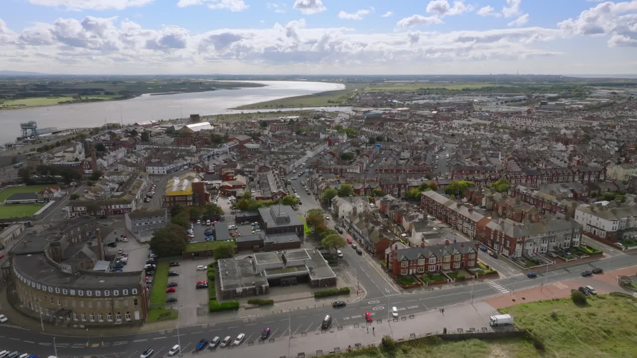 Northern Fleetwood With Camera Reverse Revealing Urban Rooftops And Headland Beach And River Wyre. Sunlight Glinting Off Distant Solar Panels. Lancashire, UK