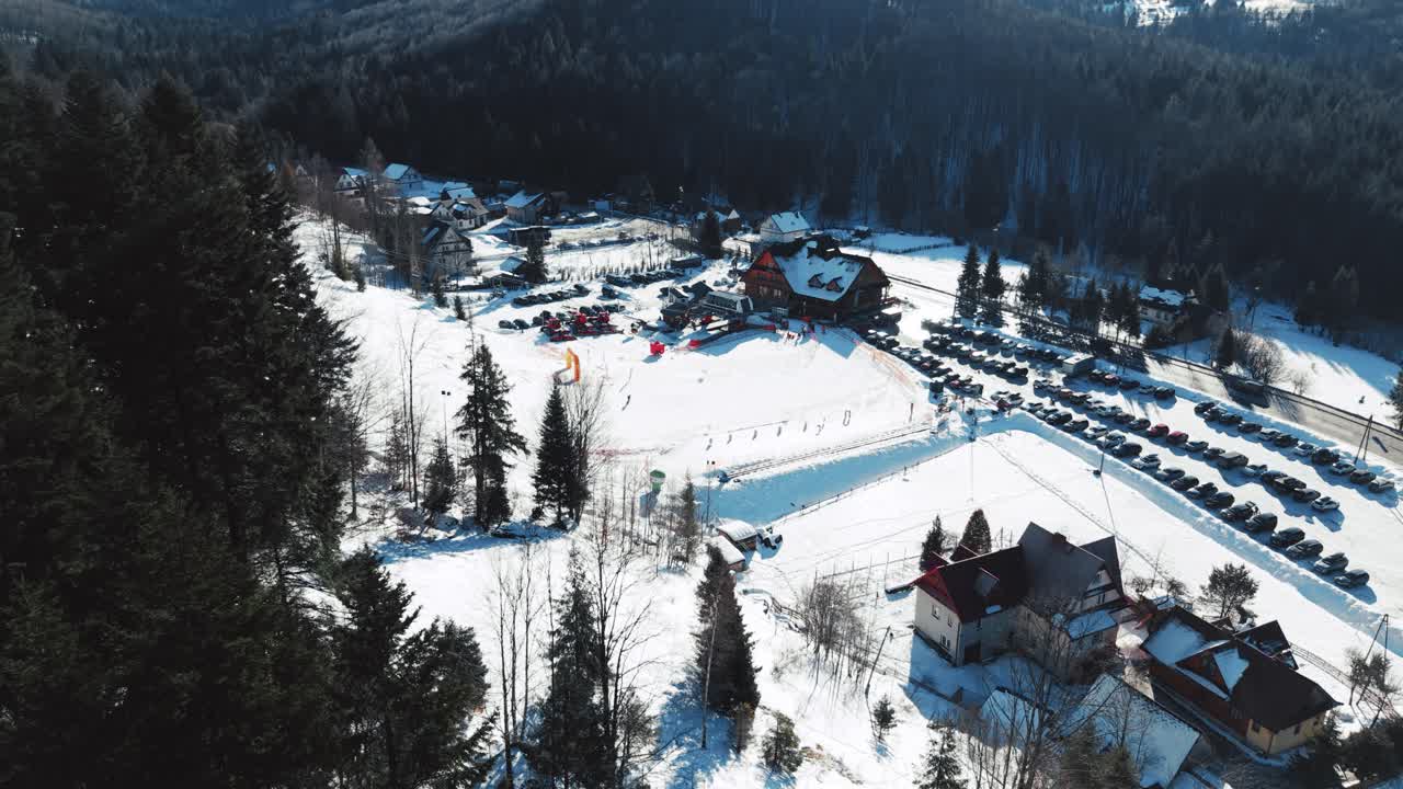 Letecký pohled na lyžařské středisko a lyžaře za slunečného jasného dne, zima.
