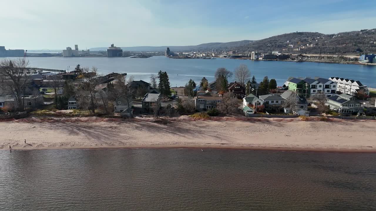 Drone Flying Parallel to Beach. moving past houses and trees. Park Point In Duluth Minnesota. Lake Superior