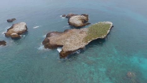 toma aérea inclinada hacia arriba de una gran formación rocosa, islas marietas, nayarit, méxico