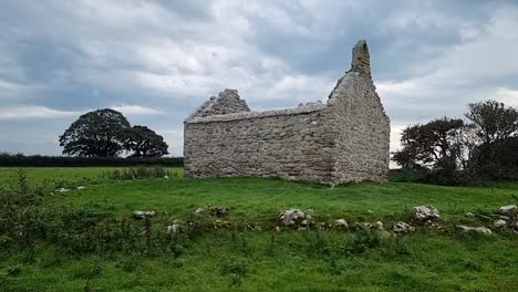 the ruins of capel lligwy on rural moelfre countryside, anglesey, north wales, slowly panning right