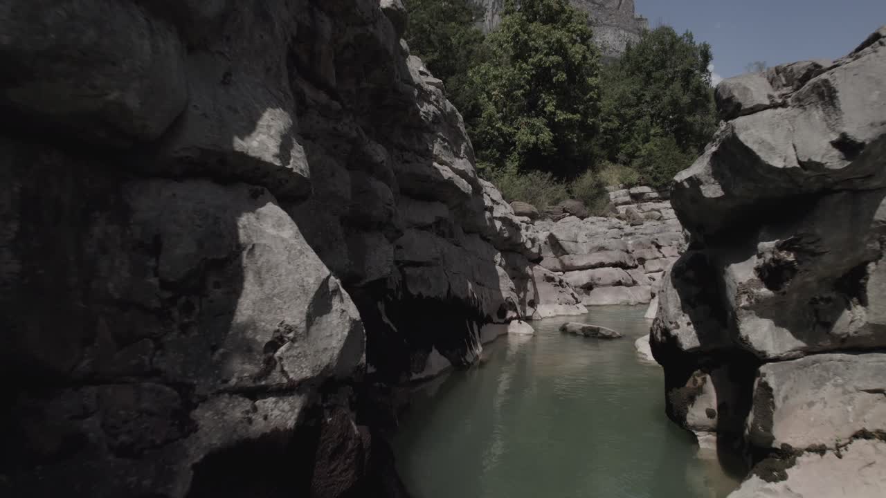 This drone video features a stunning frontal descriptive shot flying over a crystal-clear pool of the Aragón River in the Hecho Valley, nestled in the breathtaking Aragonese Pyrenees, Spain.