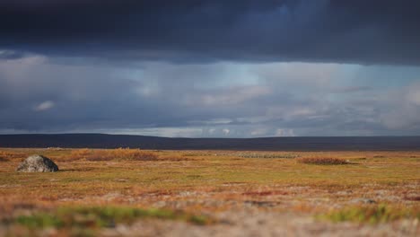 Ein-Bunter-Regenbogen-Im-Dunklen,-Stürmischen-Himmel-über-Der-Kargen-Nordischen-Landschaft