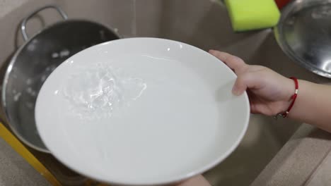 child washing dishes in the kitchen. close up of girls hands