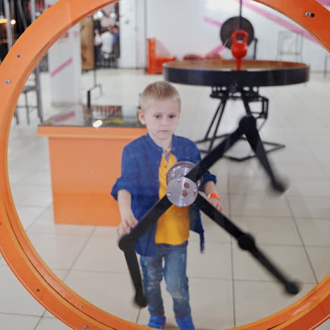 child looks at the perpetual motion machine in the children's scientific museum. scientific exhibition center.