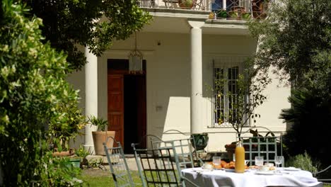 slow establishing shot of a villa with breakfast on the table outside