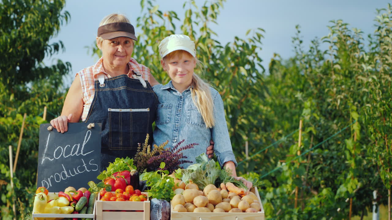 프레를 파는 농민 시장 카운터 뒤에 손녀와 함께 있는 할머니의 초상화