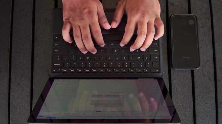 Top down view of typing hands and phone notification on wooden table, business multitasking concept, outdoor work footage scene.