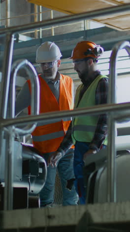 trabajadores industriales que inspeccionan la maquinaria