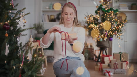 surprised woman opening wooden gift box at home during christmas