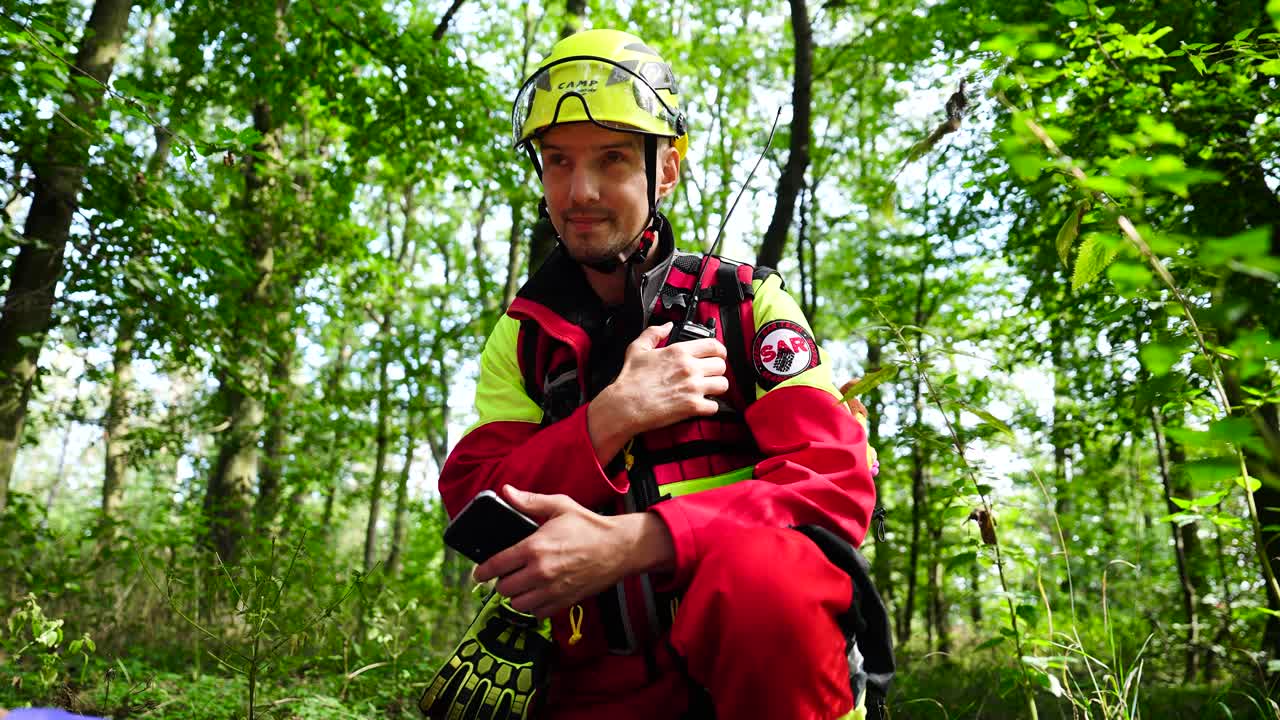 Emergency rescuer use walkie talkie to communicate from forest, Czechia