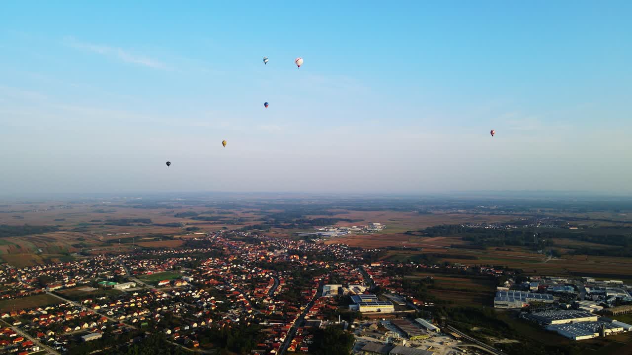 Stunning 4K aerial footage of a drone filming hot air balloons. Flying over farming fields and river. Filmed on a beautiful summer morning. Part of a hot air ballon festival in Prelog, Croatia.