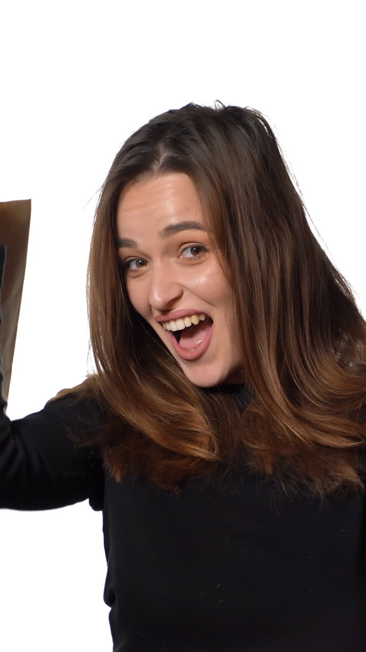 Girl enjoy shopping. Happy young woman with shopping bags on white background. Let's go shopping concept Vertical video
