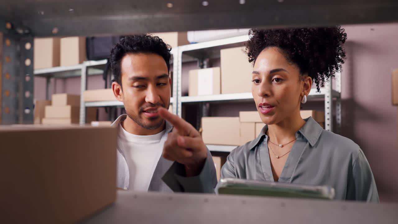 Two Business Partners Checking Inventory in a Warehouse with a Tablet