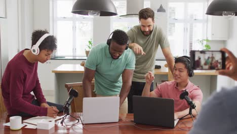 Happy-diverse-male-friends-talking-and-recording-in-living-room