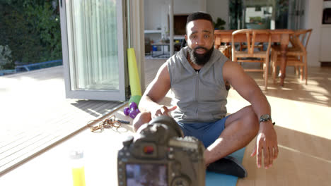 african american male fitness vlogger advicing and filming at home, slow motion