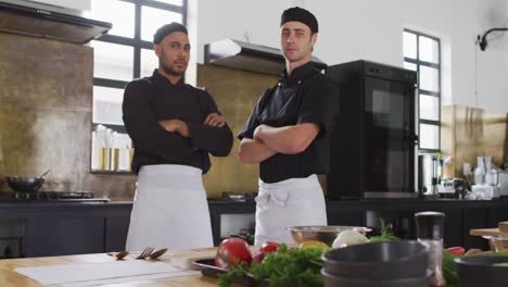cocineros caucásicos y de raza mixta mirando a la cámara y sonriendo