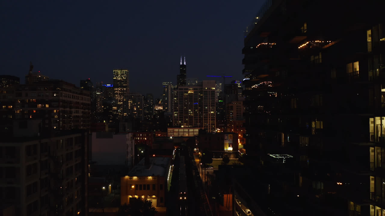 Subway Train Approaches Station Platform at Night, Chicago Skyline in Background