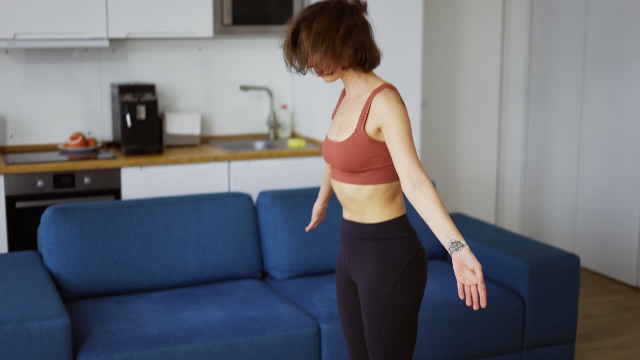 A slender woman performs asana raising up from the floor, connecting hands in namaste