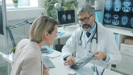 el médico discutiendo la radiografía con el paciente
