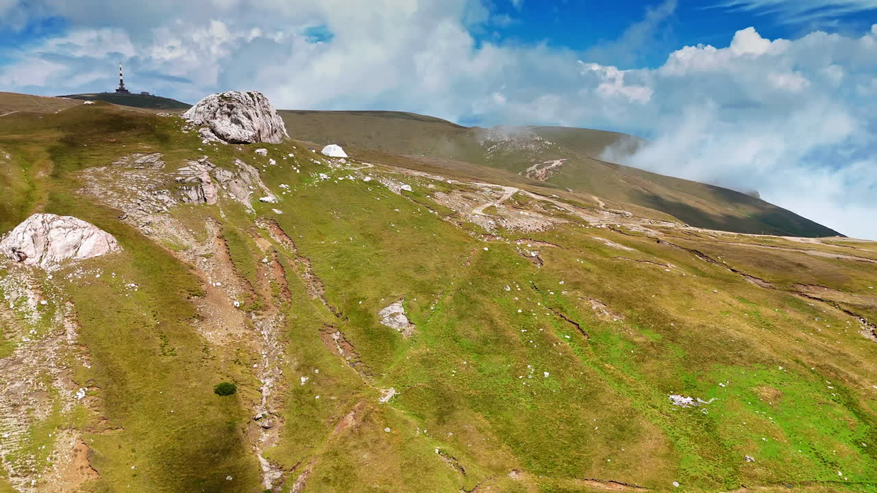 Rocky trail across Caraiman Plateau. A hiking trail winds between rocky outcrops on the plateau of Caraiman Mountain