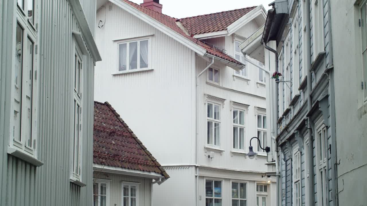 Eine statische Einstellungsaufnahme von hölzernen Wohnhäusern in Kragerø, Telemark, in hellen Farben im Südosten Norwegens an einem bewölkten Tag.