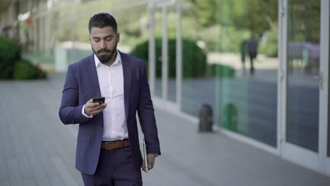 serious businessman with laptop and smartphone outdoor