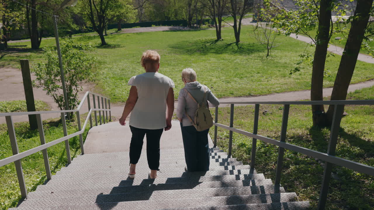 Two women walking up stairs in a park