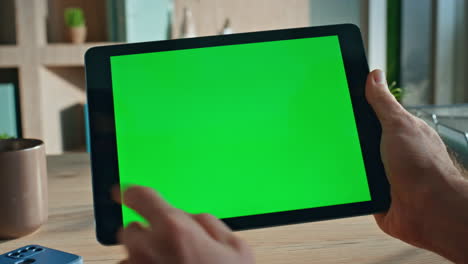closeup finger swiping greenscreen tablet in office close up. unknown freelancer