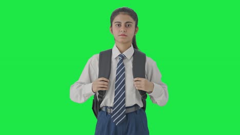 una estudiante india seria mirando la pantalla verde de la cámara