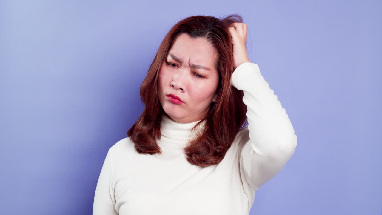 파란색 배경에 고립된 어리둥절한 감정에 대처하는 좌절된 스트레스를 받은 젊은 아시아 여성