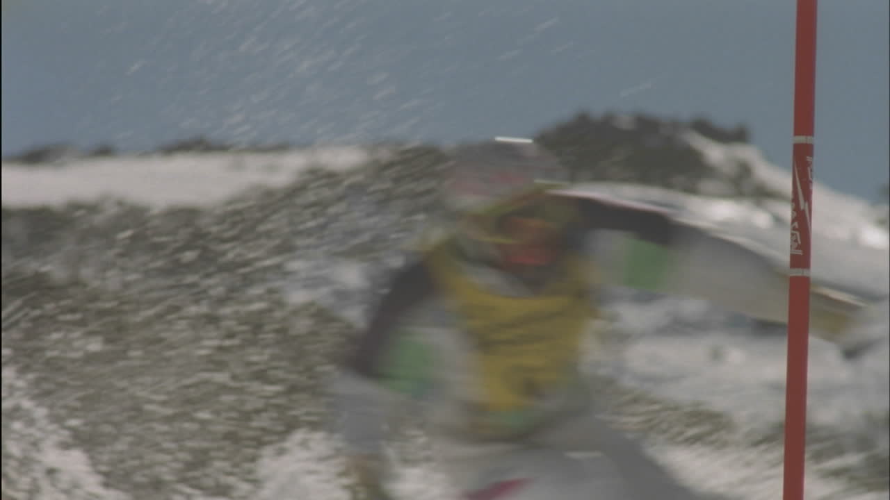 스키 선수가 슬라롬 주위를 재빨리 돌다