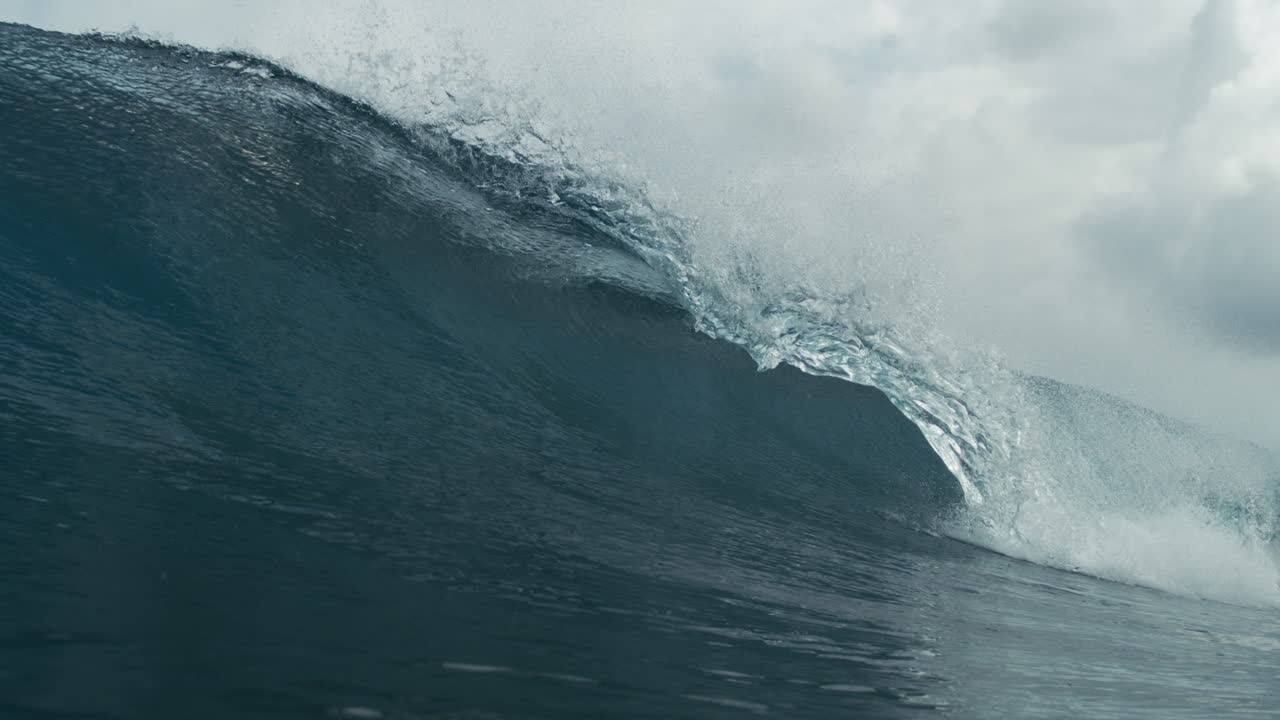 Dark ocean wave rolling under heavy sky with moody tone and dramatic smooth slow textured motion