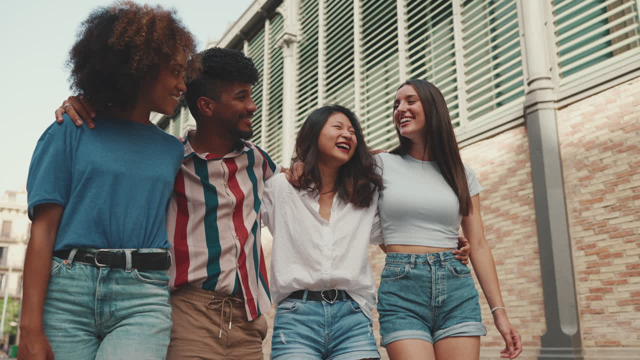 Group of diverse friends laughing and walking together in the city