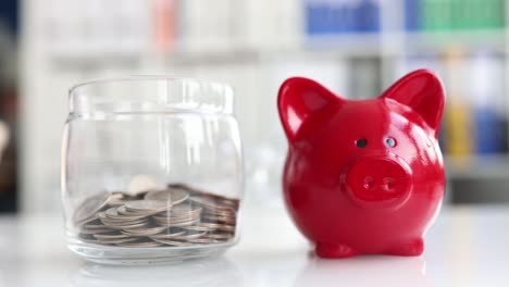 glass jar piggy bank is filled with coins with piggy bank.